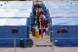 FILE - Afghan refugees are seen in an Italian Red Cross refugee camp, in Avezzano, Italy, Aug. 31, 2021.