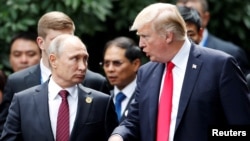 U.S. President Donald Trump and Russia's President Vladimir Putin talk during the photo session at the APEC Summit in Danang, Vietnam, Nov. 11, 2017.