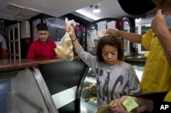 Customers buy subsidized bread at a bakery in Caracas, Venezuela, March 20, 2107.