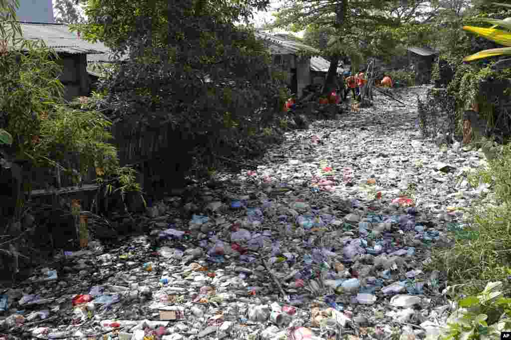 Workers collect trash during a clean-up on the Bahagia river in Bekasi, Indonesia.