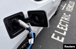 Sebuah mobil listrik sedang diisi daya di pinggir jalan, di London, Inggris, 19 Oktober 2021. (Foto: Reuters)