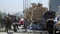 Pasukan keamanan memeriksa lokasi ledakan bom bunuh diri di Kabul, Afghanistan, Agustus 2014.