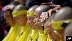 Relatives of victims of a South Korean ferry sinking that killed more than 300 a year ago, have their heads shaved during a rally against the government's plans in Seoul, South Korea, April 2, 2015.