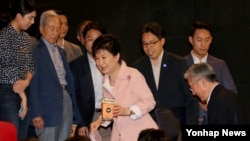 박근혜 한국 대통령이 5일 북한 실상을 담은 다큐멘터리 영화 '태양 아래'를 관람하기 위해 팝콘을 들고 영화관에 들어서고 있다.