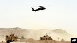Sebuah helikopter militer AS terbang di atas lokasi serangan bom bunuh diri yang menarget konvoi NATO di Kandahar, selatan Kabul, Afghanistan 2 Agustus 2017 (AP Photo)