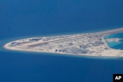 FILE - An airstrip, structures and buildings on China's man-made Subi Reef in the Spratly chain of islands in the South China Sea are seen from a Philippine Air Force C-130 transport plane of the Philippine Air Force, April 21, 2017.