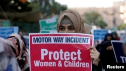 FILE - A supporter of religious and political party Jamaat-e-Islami carries a sign decrying a gang rape that occurred along a highway and condemning violence against women and girls, during a demonstration in Karachi, Pakistan, Sept. 11, 2020.