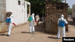Nhân viên y tế phun thuốc khử trùng tại một đền thờ Hồi giáo ở Bamako, Mali.