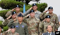 FILE - U.S. and South Korean soldiers salute during a change of command and responsibility ceremony at Yongsan Garrison, a U.S. military base, in Seoul, South Korea, Aug. 11, 2017.