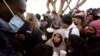 En esta imagen de archivo de febrero de 2021, solicitantes de asilo reciben comida mientras esperan noticias sobre los cambios de la política migratoria estadounidense en la frontera, en Tijuana, México. 