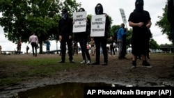 Antifašistički aktivisti sa napisima "Premoć belaca je terorizam"