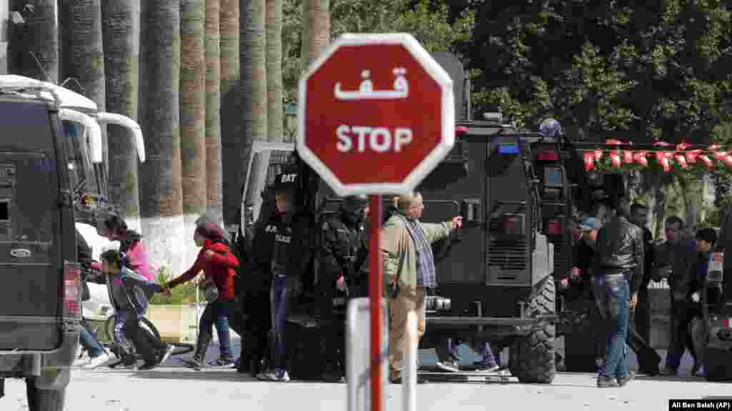 Rescue workers evacuate children, left, and adults after gunmen opened fire at the Bardo museum in Tunisia's capital, Wednesday, March 18, 2015 in Tunis.