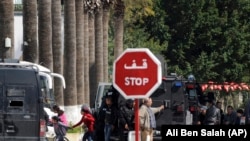 Rescue workers evacuate children, left, and adults after gunmen opened fire at the Bardo museum in Tunisia's capital, Wednesday, March 18, 2015 in Tunis.