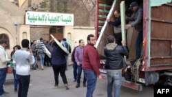 Egyptian Coptic Christians unload their belongings from a truck as they arrive to take refuge at the Evangelical Church in the Suez Canal city of Ismailia, Feb. 24, 2017.