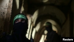 Dua pejuang Palestina dari Brigade Izz el-Deen al-Qassam tampak siaga di dalam terowongan di Jalur Gaza (18/8).