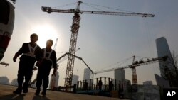 Workers walk out from a construction site at the Central Business District of Beijing, China.