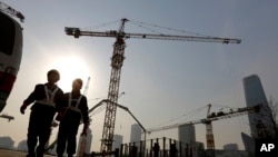 Workers walk out from a construction site at the Central Business District of Beijing, China, Jan. 20, 2015.