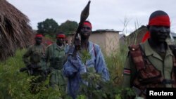 FILE - Sudan People's Liberation Army (SPLA-IO) rebels walk during an assault on government Sudan People's Liberation Army (SPLA) soldiers in the town of Kaya, South Sudan, Aug. 26, 2017.