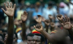 Para pengunjuk rasa Papua mengangkat tangan mereka saat rapat umum menyerukan kemerdekaan di Jayapura, Papua,16 Oktober 2008. (Foto: Reuters/Oka Daud Barta)