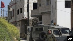 Israeli troops operate in the West Bank village of Awarta, after five people were killed in the nearby Jewish settlement of Itamar, March 12, 2011