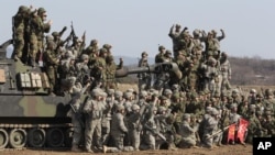 South Korean and U.S. army, gray, soldiers cheer after a live fire drill during the annual Foal Eagle maneuvers near Rodriguez Range in Pocheon, south of the demilitarized zone that divides the two Koreas, South Korea, March 15, 2012.