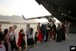 کابل ایئرپورٹ سے ملک چھوڑنے کے خواہش مند افراد طیارے میں سوار ہو رہے ہیں۔