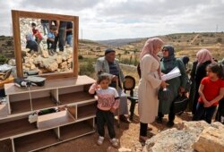 Anggota keluarga Palestina memeriksa barang-barang mereka setelah Israel menghancurkan rumah mereka yang terletak di "Area C" Tepi Barat yang diduduki. (Foto: AFP)