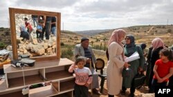 Keluarga Palestina berkumpul di dekat barang-barang mereka setelah pasukan keamanan Israel menghancurkan rumah mereka di Halhoul, utara kota Hebron, Tepi Barat yang diduduki Israel (foto: ilustrasi). 