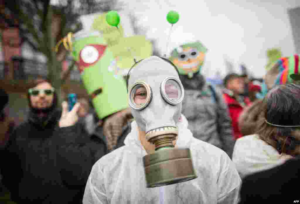 A woman wears a gas mask during a demonstration organized by environmental NGOs in Frankfurt am Main, central Germany on the eve of the official opening of a 195-nation UN climate summit in Paris.