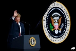 FILE - President Donald Trump waves after delivering remarks at a Foxconn facility, June 28, 2018, in Mount Pleasant, Wis.