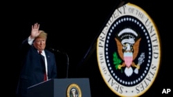 El presidente Donald Trump saluda a seguidores tras pronunciar un discurso en una planta de Foxconn en Mt. Pleasant, Wisconsin, el jueves 28 de junio de 2018.
