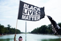 Muškarac drži zastava Black Lives Matters u Washingtonu.