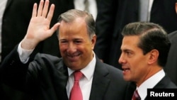 Mexico's outgoing Finance Minister Jose Antonio Meade waves next to President Enrique Pena Nieto during an event where Pena Nieto announced the resignation of Antonio Meade, at Los Pinos presidential residence in Mexico City, Mexico, Nov. 27, 2017. 