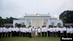 Indonesian President Joko Widodo shakes hands with members of his new cabinet after they were unveiled at the presidential palace in Jakarta, Oct. 26, 2014. (REUTERS/Darren Whiteside)