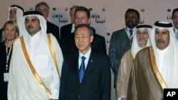 ທ່ານ Ban Ki-Moon ຢືນຢູ່ທາງຂ້າງຈາກອົງມົງກຸດ Sheikh Tamim bin Hamad al-Thani ແຫ່ງ Qatar .ໃນການຖ່າຍຮູບຮ່ວມກັນຂອງບັນດາລັດຖະມົນຕີຕ່າງປະເທດທີ່ມາຮ່ວມກອງປະຊຸມ ທີ່ນະຄອນຫລວງ Doha ວັນທີ 13 ເມສາ, 2011
