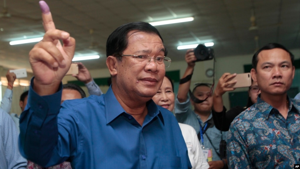 Cambodian Prime Minister Hun Sen of the Cambodian People's Party shows off his inked finger after voting in local elections at Takhmau polling station in Kandal province, southeast of Phnom Penh, Cambodia, Sunday, June 4, 2017. (AP Photo/Heng Sinith)
