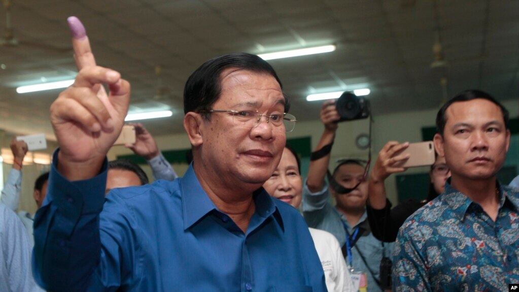 FILE - Cambodian Prime Minister Hun Sen of the Cambodian People's Party shows off his inked finger after voting in local elections at Takhmau polling station in Kandal province, southeast of Phnom Penh, Cambodia, Sunday, June 4, 2017. (AP Photo/Heng Sinith)