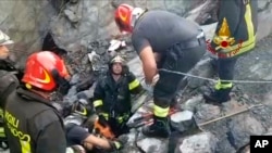 This frame taken from a video released by the Italian firefighters, shows firefighters working on the site of the collapsed Morandi highway bridge in Genoa, northern Italy, Aug. 14, 2018.