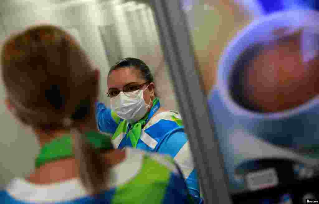 Una mujer usa una máscara como medida de precaución debido al coronavirus mientras trabaja en el aeropuerto Salgado Filho en Porto Alegre, Brasil. &nbsp;