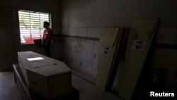 A volunteer sits beside a window, while waiting for the relatives of a deceased who died due to intense hot weather to collect the body, at Edhi Foundation morgue in Karachi, Pakistan, June 21, 2015. 