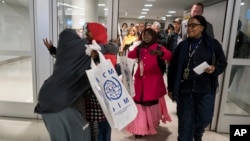 FILE - Members of a Somali family are seen arriving at John F. Kennedy International Airport in New York, March 8, 2017. Confusion abounds following a U.S. Supreme Court decision Monday to significantly narrow the scope of President Donald Trump's original executive order temporarily banning entry to the U.S. for citizens from six predominantly Muslim countries. 