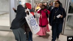 Halima Mohamed, embraces her daughter Muzamil Shalle, 14, left, as her other daughter Miski Shalle, 11, center, approaches. Mohamed sees her children for the first time in seven years in New York, March 8, 2017. The parents, who are from Somalia, but have been living in Mechanicsburg, Pennsylvania, were originally scheduled to receive the children earlier this year, but the process was delayed due to the White House travel ban executive order.