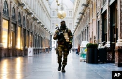 FILE - In this Thursday, Nov. 26, 2015 file photo, a Belgian Army soldier walks through the Galleries Royal Saint-Hubert in the center of Brussels. Some experts say it will take months for Europeans to psychologically adapt to life after the Paris attacks.