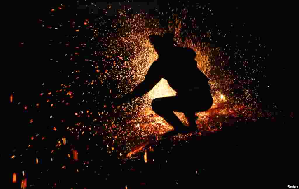 A Vietnamese man from the Pa Then minority group jumps into a fire during a ritual ceremony at the Vietnam Ethnic Minority Cultural Village, outside Hanoi. 