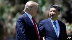 President Donald Trump and Chinese President Xi Jinping walk together after their meetings at Mar-a-Lago, April 7, 2017, in Palm Beach, Florida. 