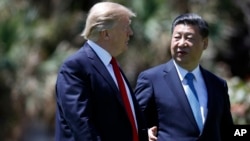 President Donald Trump and Chinese President Xi Jinping walk together after their meetings at Mar-a-Lago, April 7, 2017, in Palm Beach, Florida. 