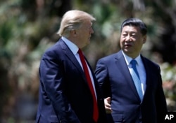 U.S. President Donald Trump and Chinese President Xi Jinping walk together after their meeting at Mar-a-Lago, in Palm Beach, Florida, April 7, 2017.