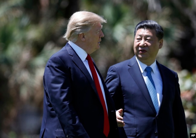 President Donald Trump and Chinese President Xi Jinping walk together after their meetings at Mar-a-Lago, April 7, 2017, in Palm Beach, Florida.