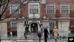 FILE - People walk near the campus center at Princeton University in Princeton, N.J., Dec. 9, 2013. 