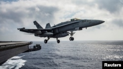 FILE - A U.S. Navy F/A-18E Super Hornet launches from the flight deck of the aircraft carrier USS Dwight D. Eisenhower in the Mediterranean Sea, June 28, 2016.